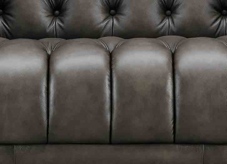 Close-up of a brown leather sofa with tufted backrest