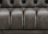 Close-up of a brown leather sofa with tufted backrest
