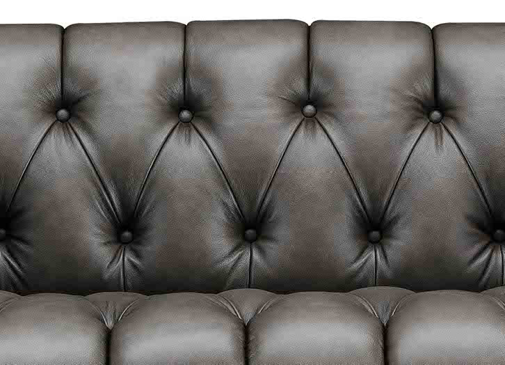 Close-up of a brown leather sofa with tufted backrest