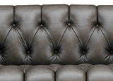 Close-up of a brown leather sofa with tufted backrest