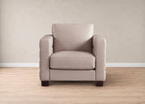 A single upholstered armchair in a light beige or taupe leather-like material, shown centered against a neutral beige wall and light wood floor.