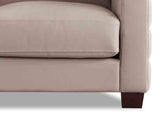 Close-up of a beige sofa with brown legs on a white background