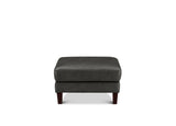 A dark gray upholstered ottoman with a rectangular cushioned top and short dark wooden legs, shown against a plain white background.