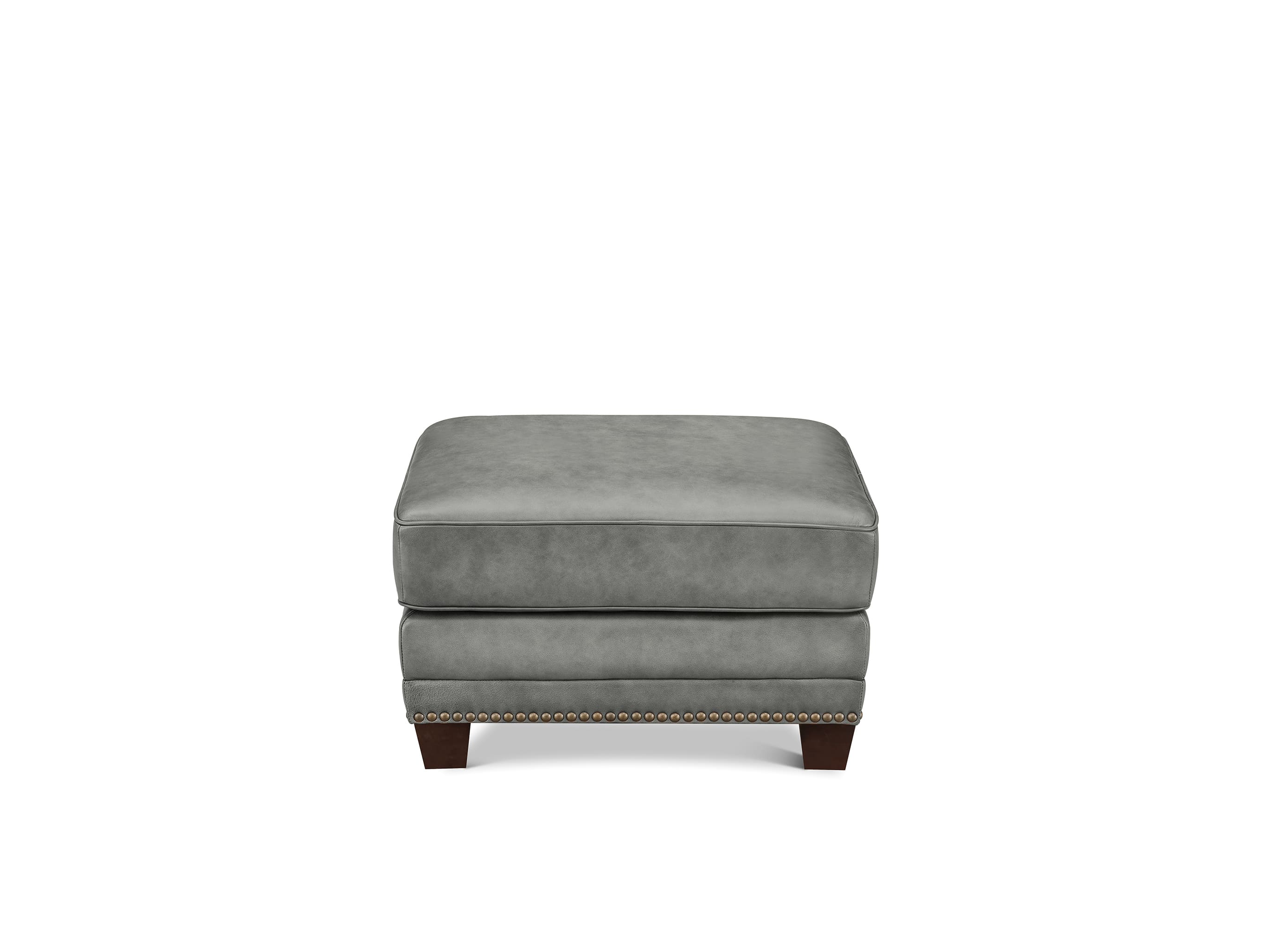 A square gray upholstered ottoman with dark wood legs and nailhead trim, shown against a plain white background.