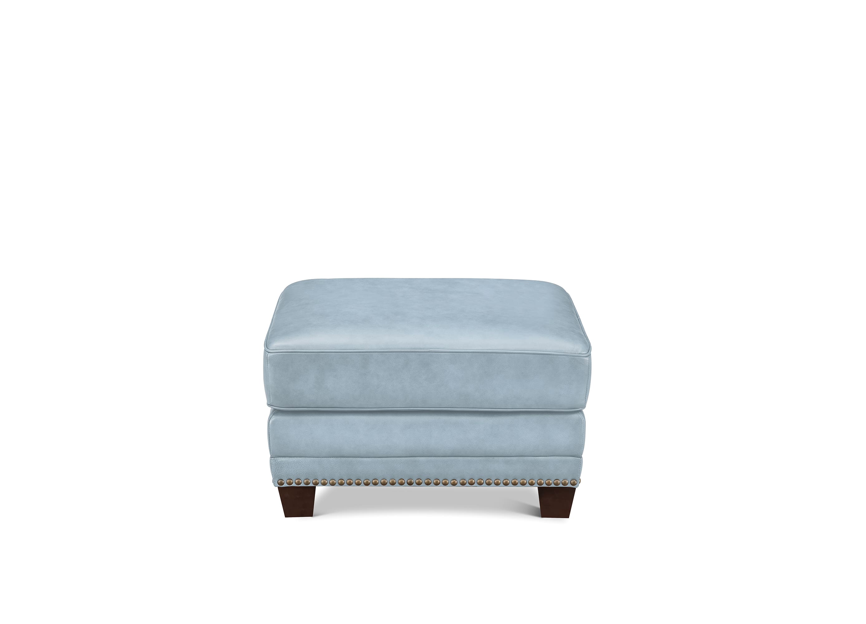 A light blue upholstered ottoman with dark wood legs and nailhead trim, shown against a plain white background.