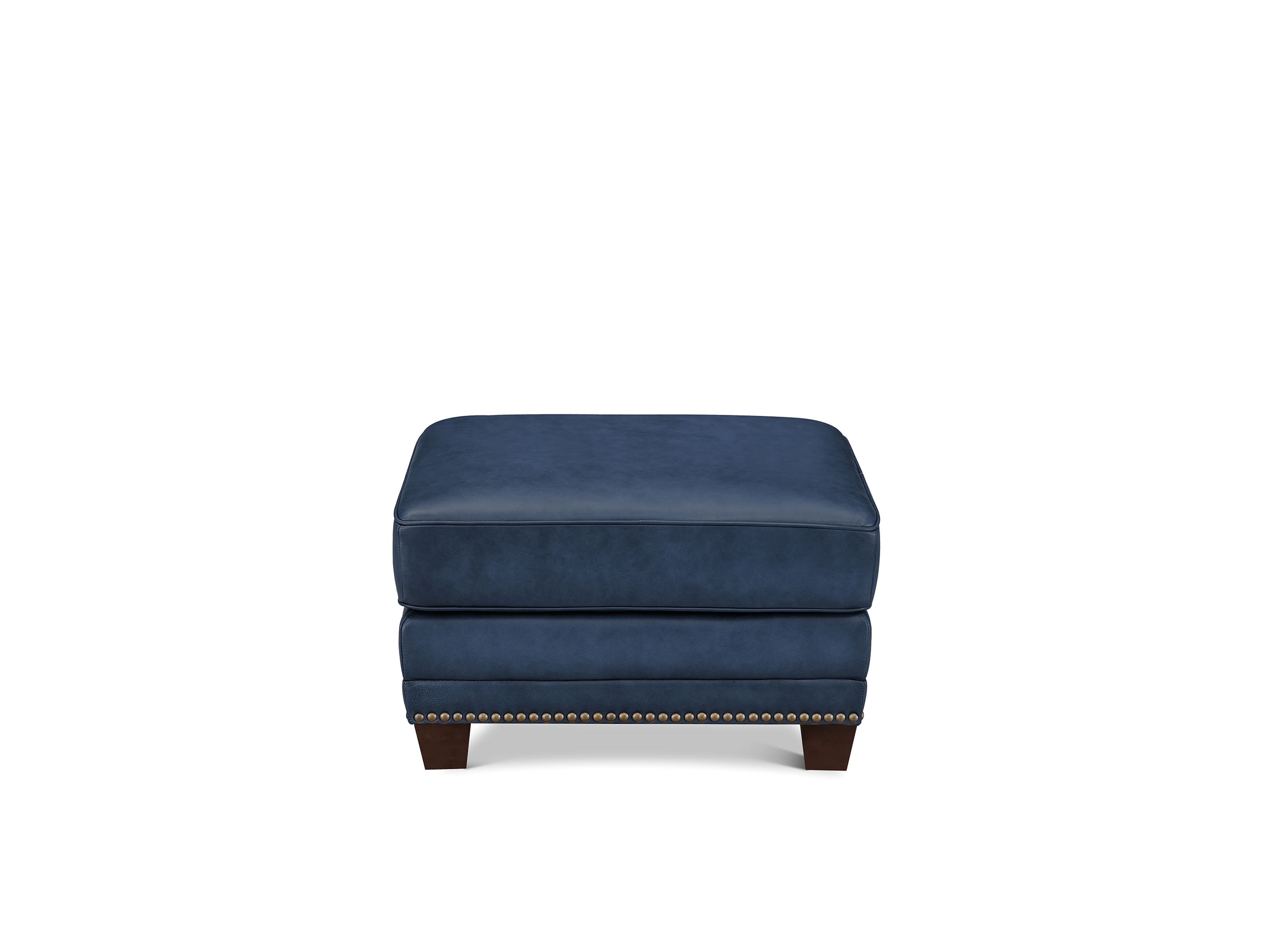 A navy blue upholstered ottoman with dark wood legs and nailhead trim, shown against a plain white background.
