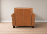A single upholstered armchair shown from the back, upholstered in warm tan leather or faux leather, set against a neutral beige wall and light wood floor.