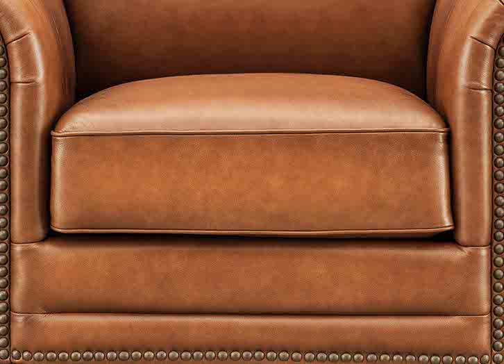 Close-up of a brown leather armchair with studded details