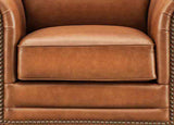 Close-up of a brown leather armchair with studded details