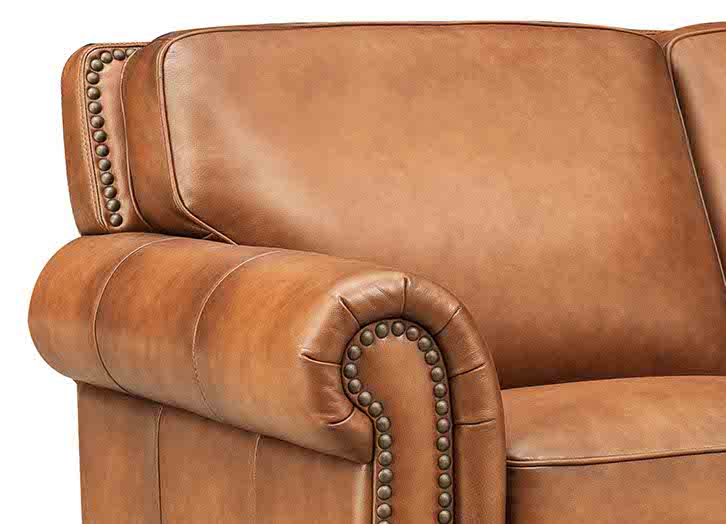 Brown leather sofa with decorative nailhead trim on a white background