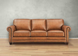 Brown leather sofa against a gray wall on a wooden floor