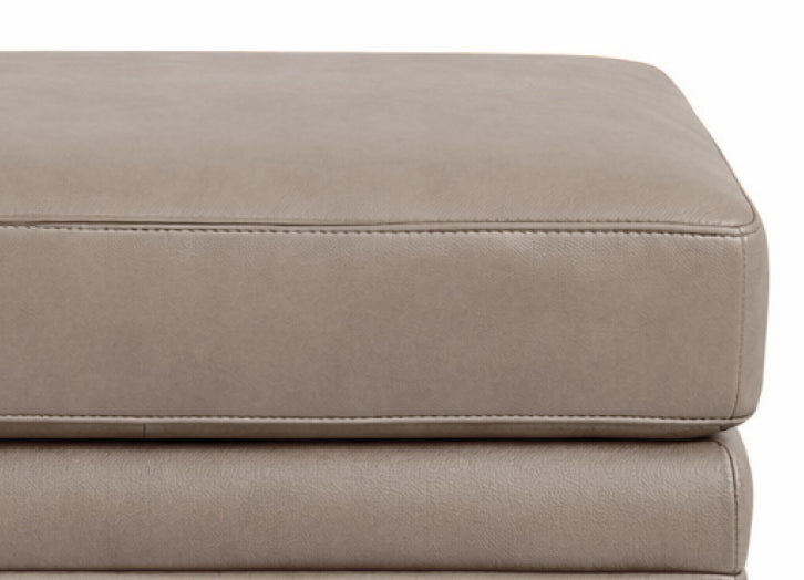 Close-up of a beige leather ottoman on a white background