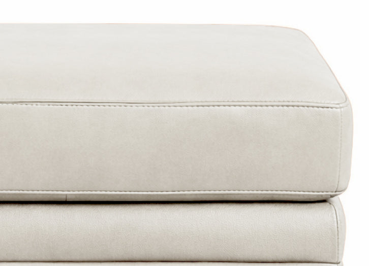 Close-up of a light gray leather ottoman on a white background