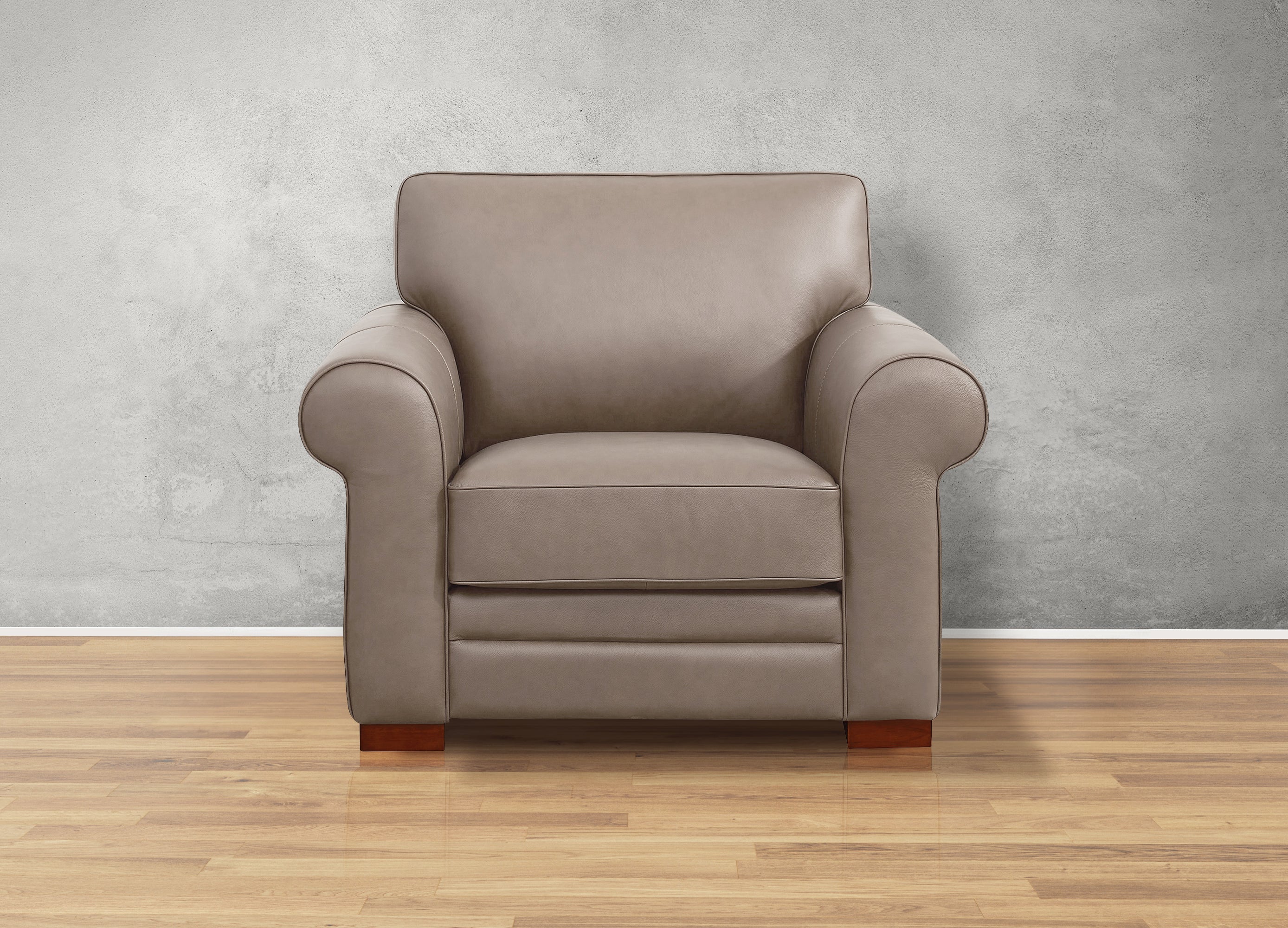 Gray armchair on a wooden floor with a gray wall background