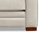 Close-up of a beige sofa with wooden leg on a white background