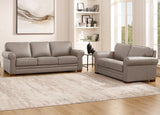 Gray leather sofa set in a living room with a rug and bookshelf.