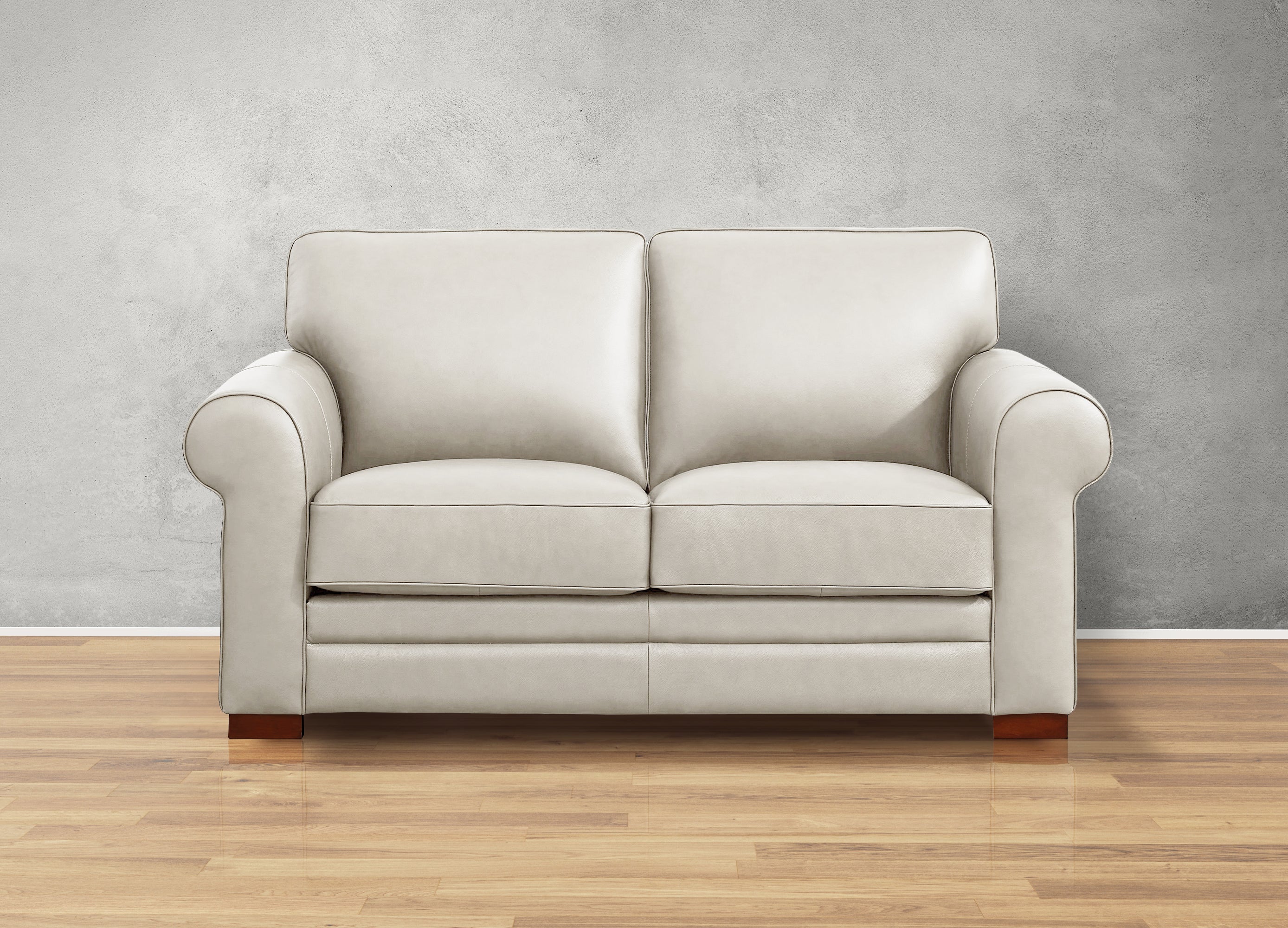 Beige sofa on a wooden floor with a gray wall background