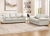 Light gray sofa set in a living room with a rug and wall art.