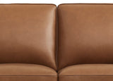 Close-up of a brown leather sofa with a plain background