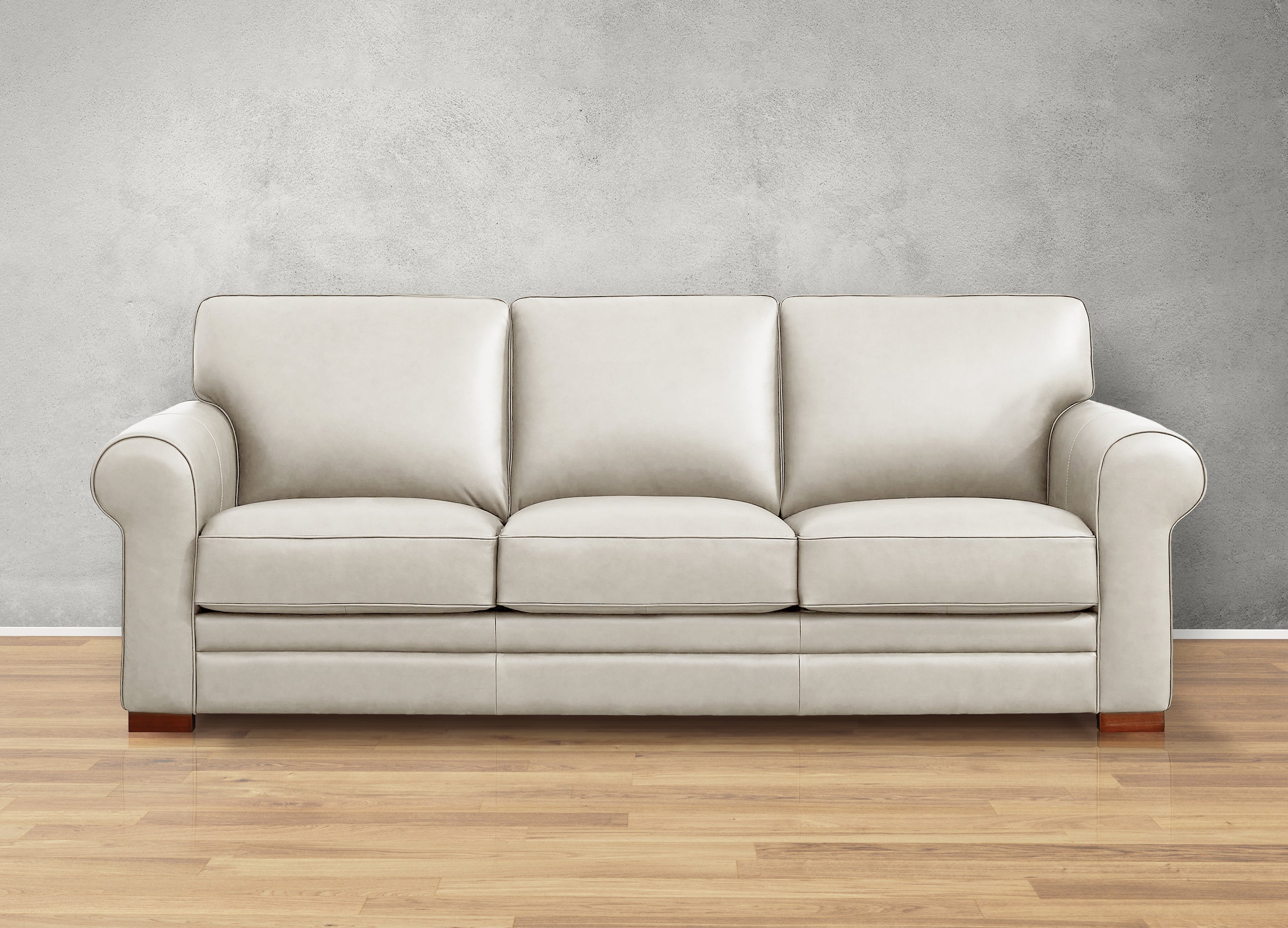 Beige sofa on a wooden floor with a gray wall background