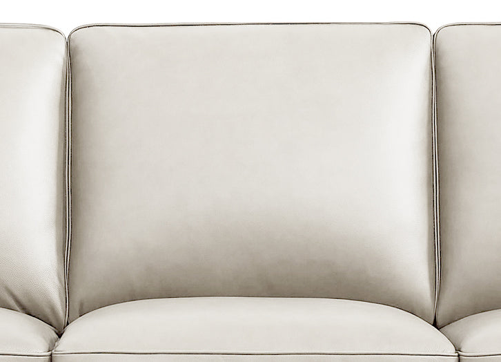 Close-up of a beige leather sofa with a neutral background