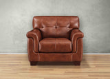 Brown leather armchair against a gray wall on a wooden floor