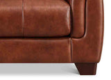 Close-up of a brown leather sofa corner on a white background