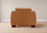 A modern armchair with a warm camel-brown faux leather upholstery, featuring a segmented backrest and dark brown wooden legs, shown from the rear against a neutral beige wall and light wood floor.
