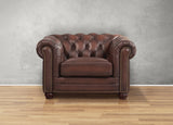 Brown leather armchair with tufted backrest on a wooden floor and gray wall background