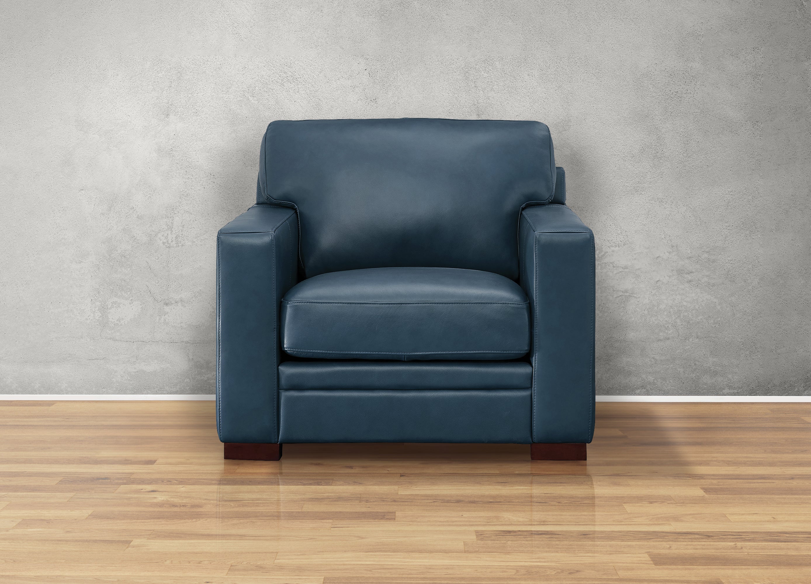 Blue armchair against a gray wall on a wooden floor