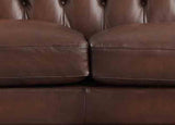 Close-up of a brown leather sofa with tufted backrest