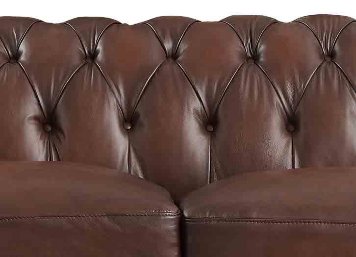 Close-up of a brown leather sofa with tufted backrest