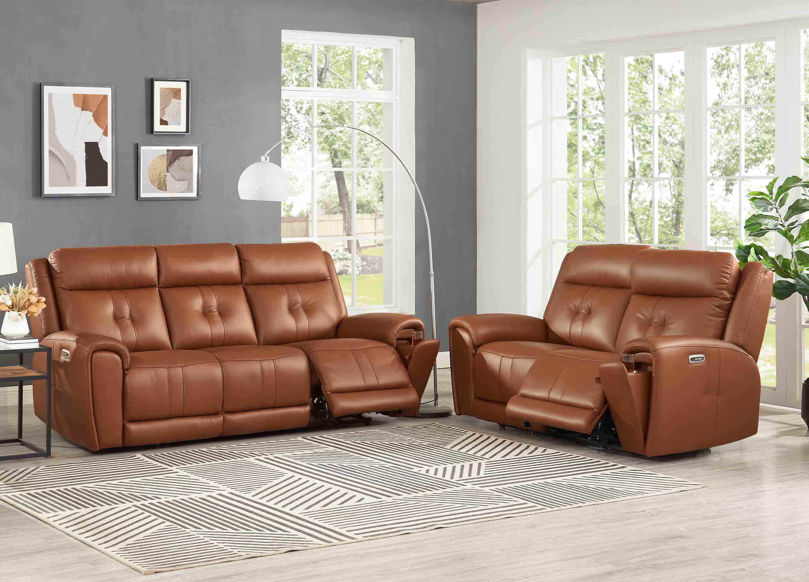 Brown leather reclining sofa set in a living room with large windows.